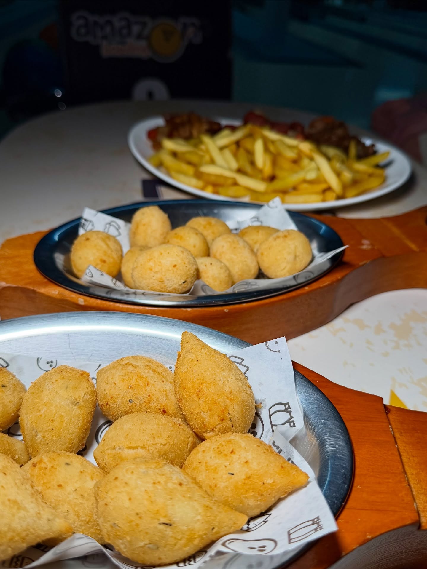 Porções de salgados e fritas na mesa do evento